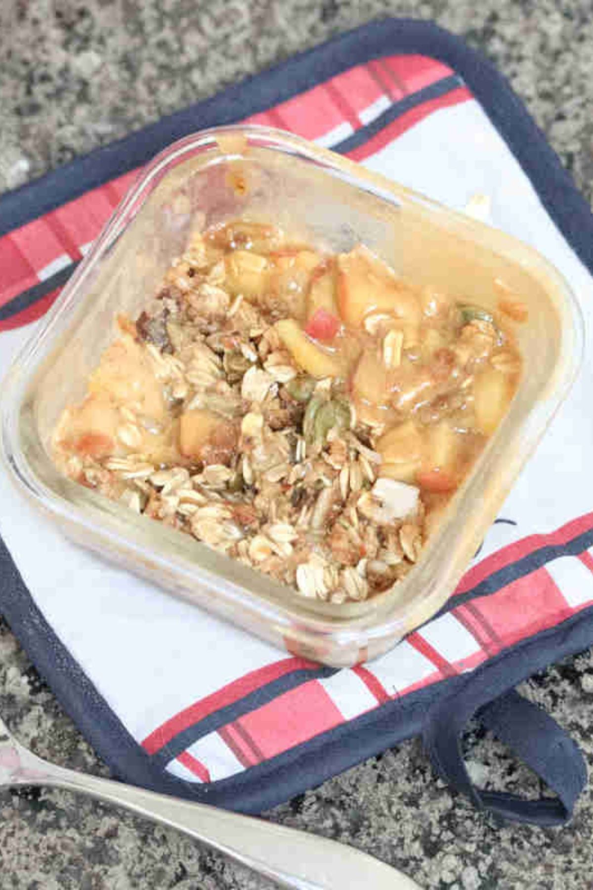 Protein apple crumble with oat topped in a single serve ramekin on a hot pad.